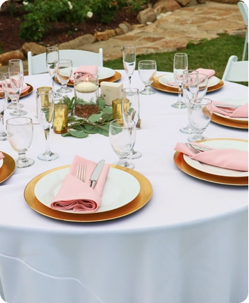 A table set with plates and glasses for a wedding.